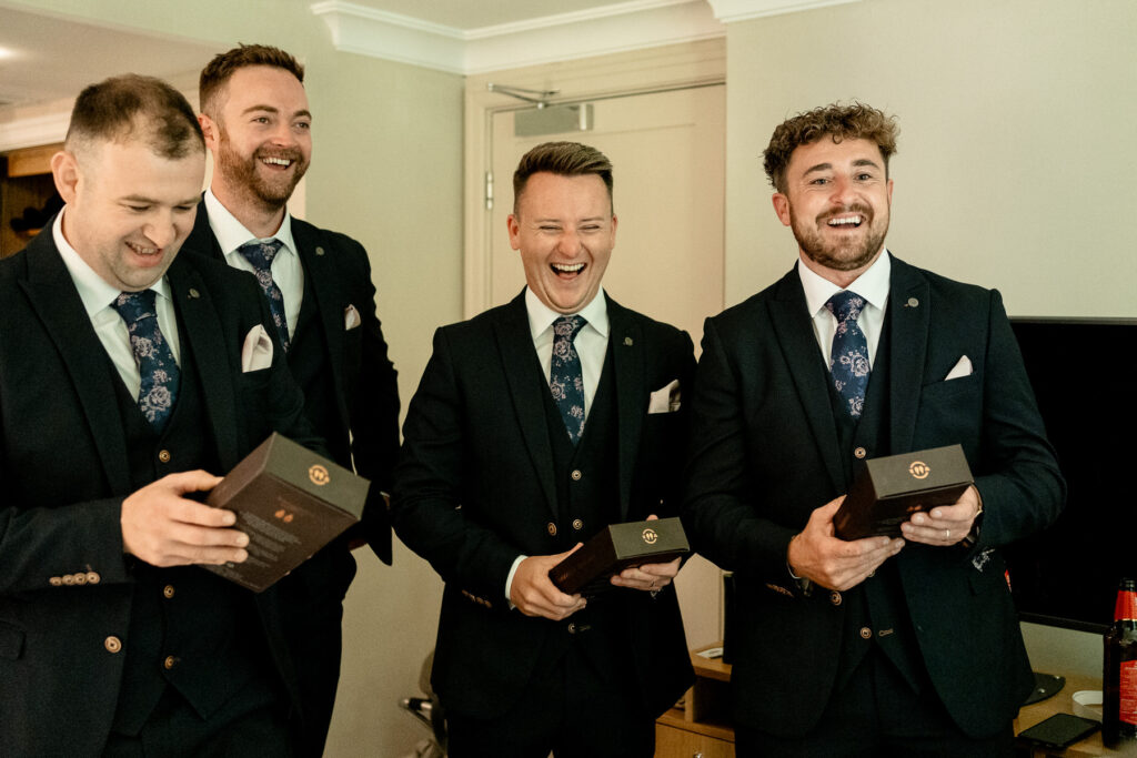 Groomsmen laughing at Ellie and Sam's Rhinefield House Hotel wedding in the New Forest