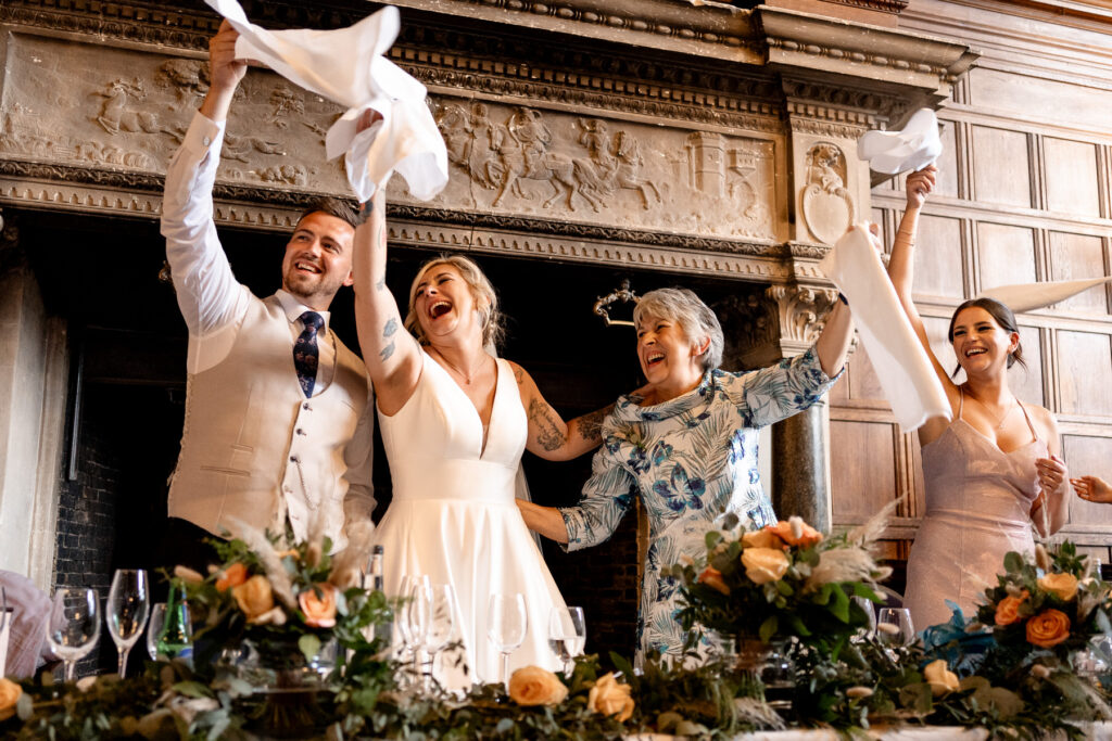 Rhinefield House Hotel Wedding photographer for Ellie and Sam - surprise singing waitors napkin waving