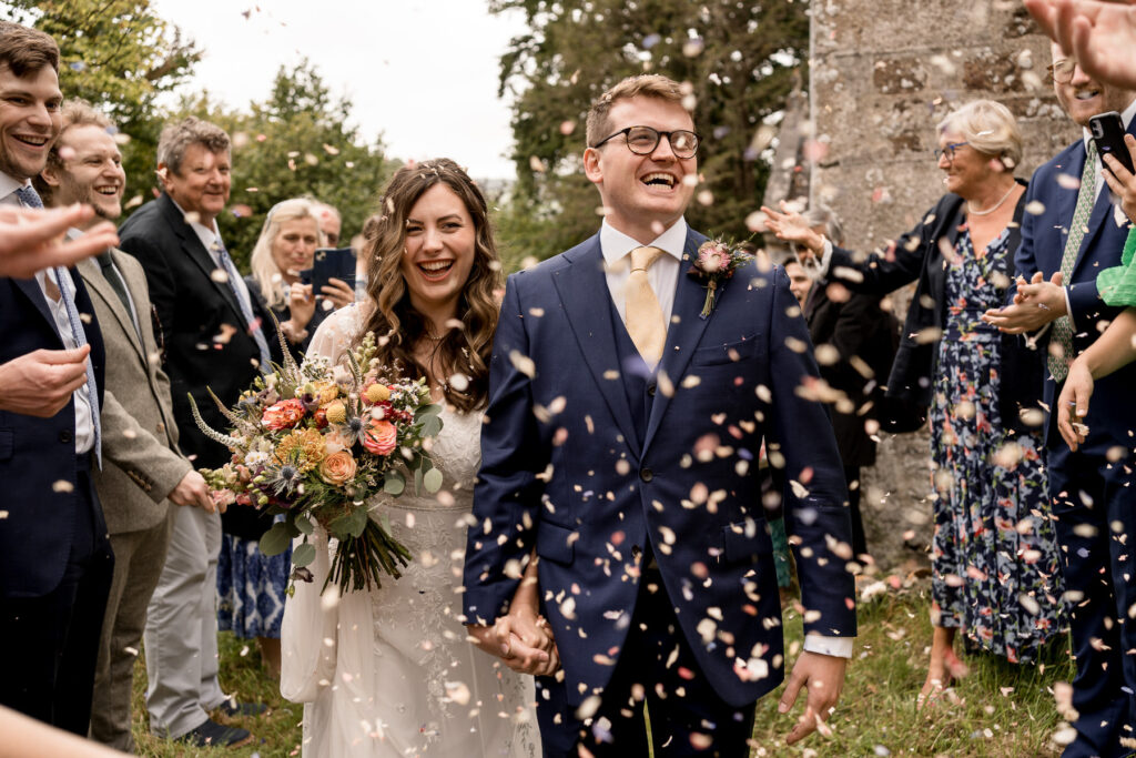 Bride and groom outside The Great Barn Devon after church ceremony