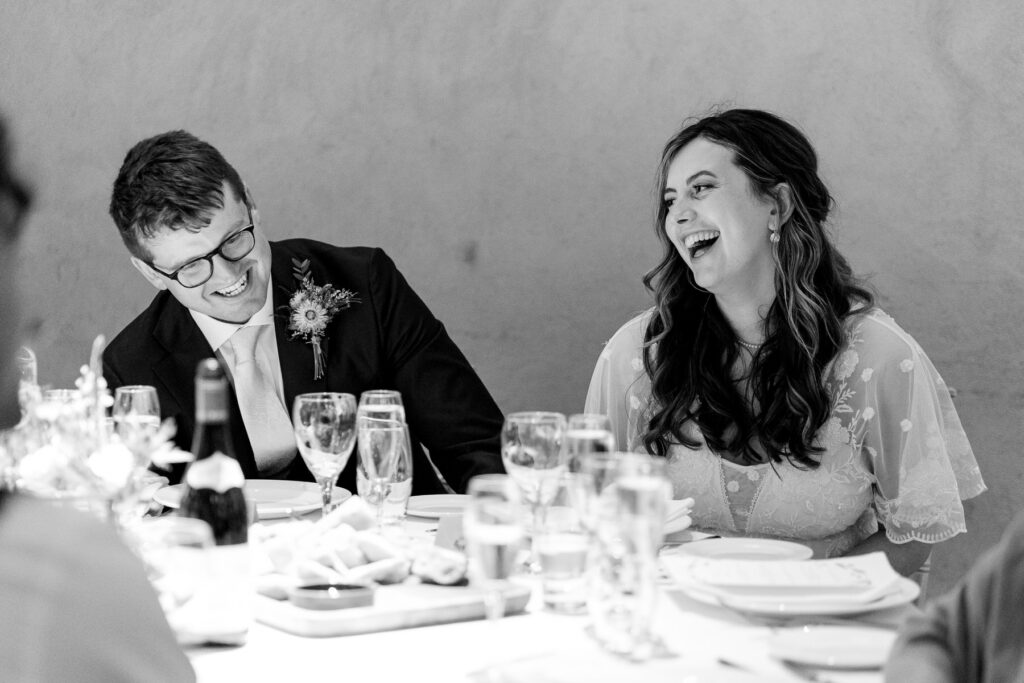 Guests laughing during speeches at The Great Barn Devon