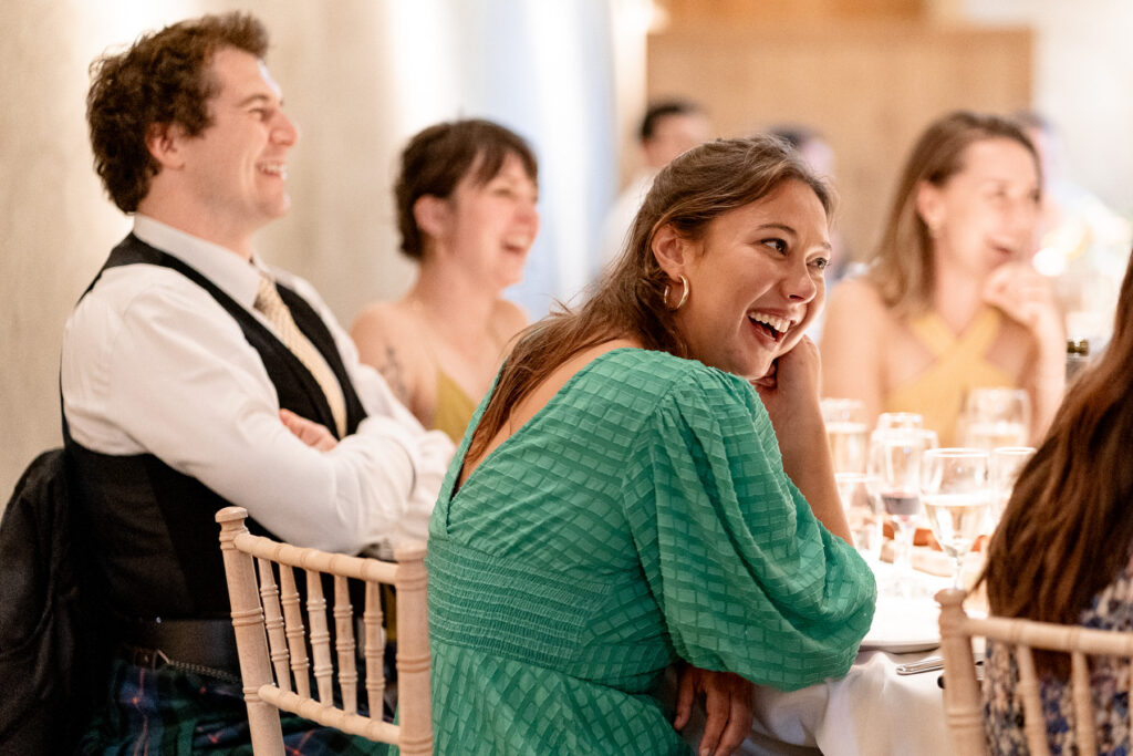 Guests laughing during speeches at The Great Barn Devon