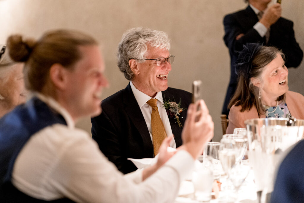Guests laughing during speeches at The Great Barn Devon