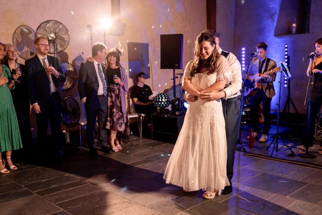 Bride and groom first dance inside The Great Barn Devon