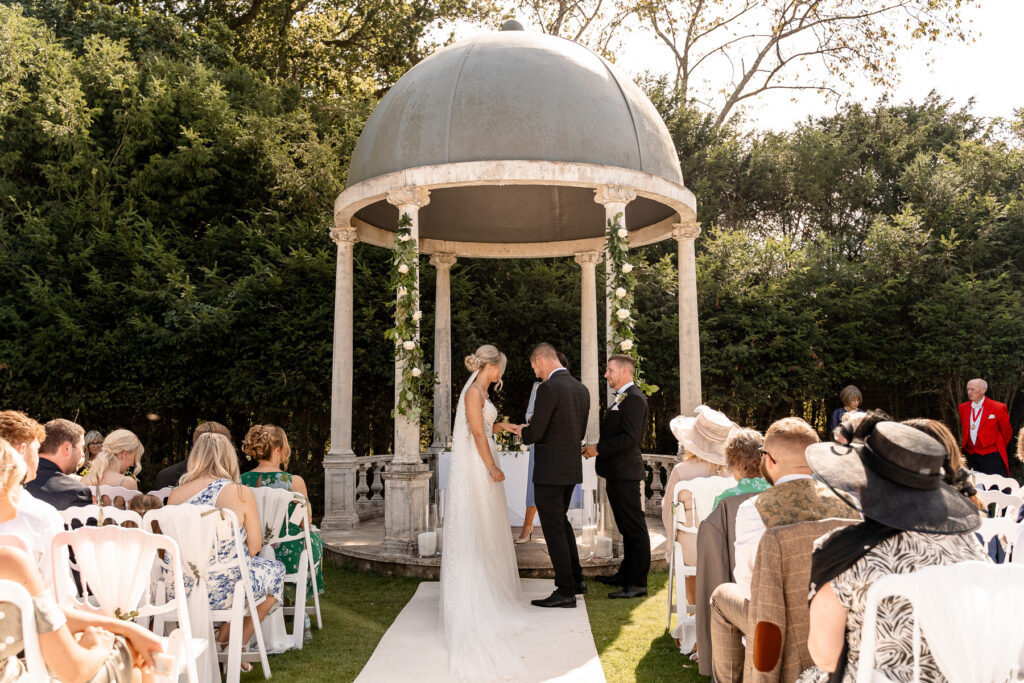Bride and groom exchanging vows during their Rhinefield House wedding ceremony in the New Forest.