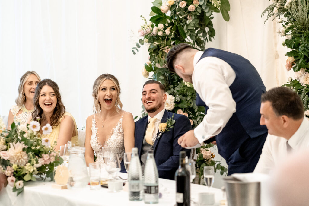 bride laughing during speeches at a Summer wedding at Audleys Wood