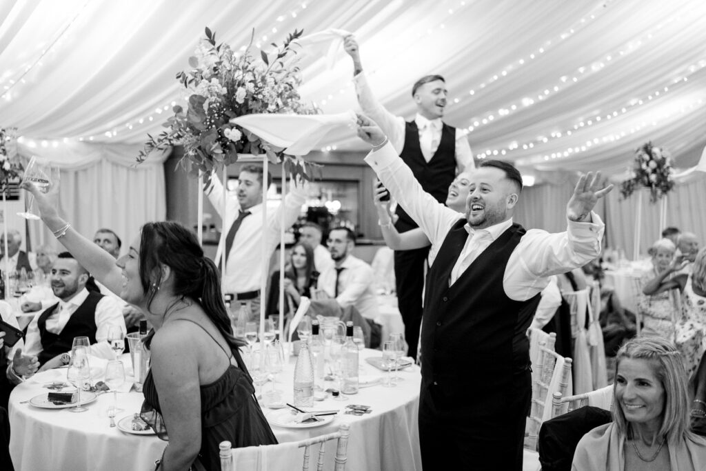 guests cheering bride and groom at a Summer wedding at Audleys Wood