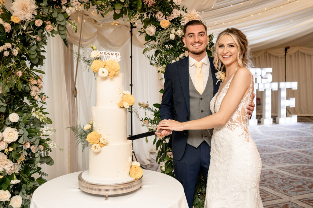cutting the cake at a Summer wedding at Audleys Wood